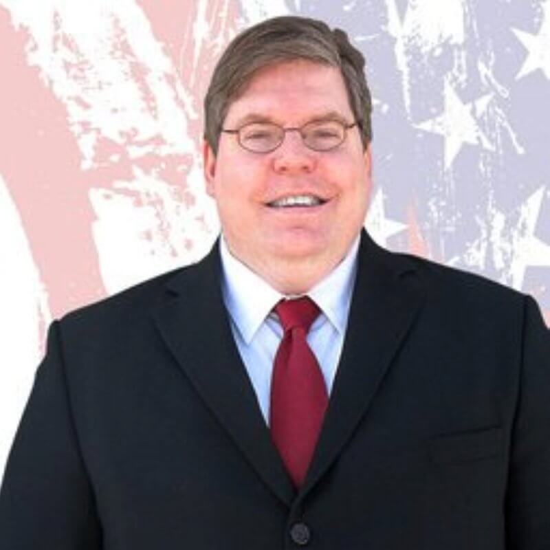 Vermont personal injury attorney Thomas Bixby in front of an American flag.