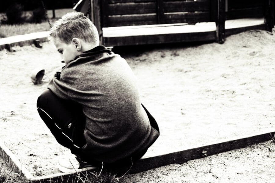 Former Boy Scout kneeling on a playground.