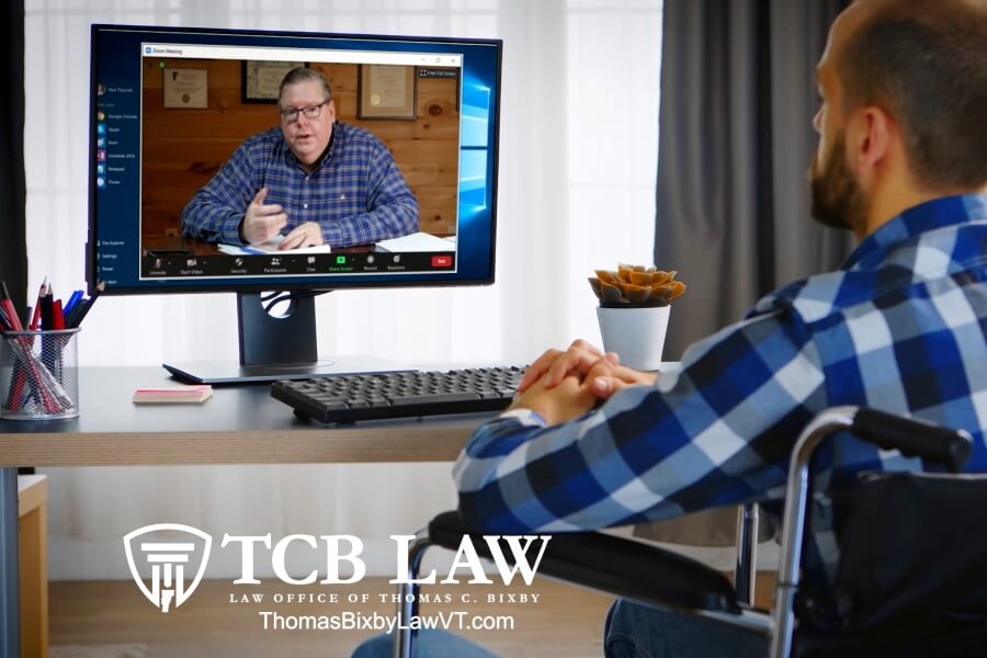 Lawyer Tom Bixby displayed on monitor meeting with disabled law client.