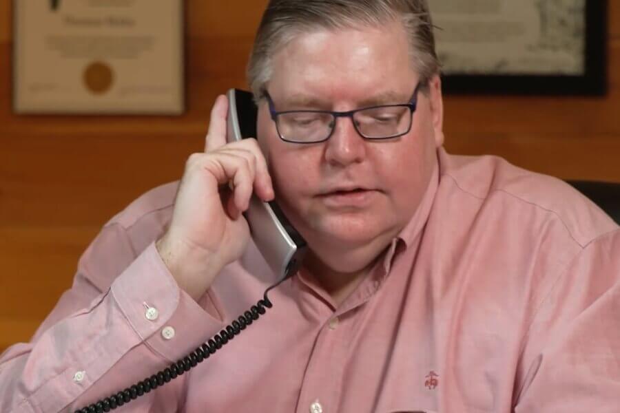 Tom Bixby, attorney at law, speaking on phone with client.