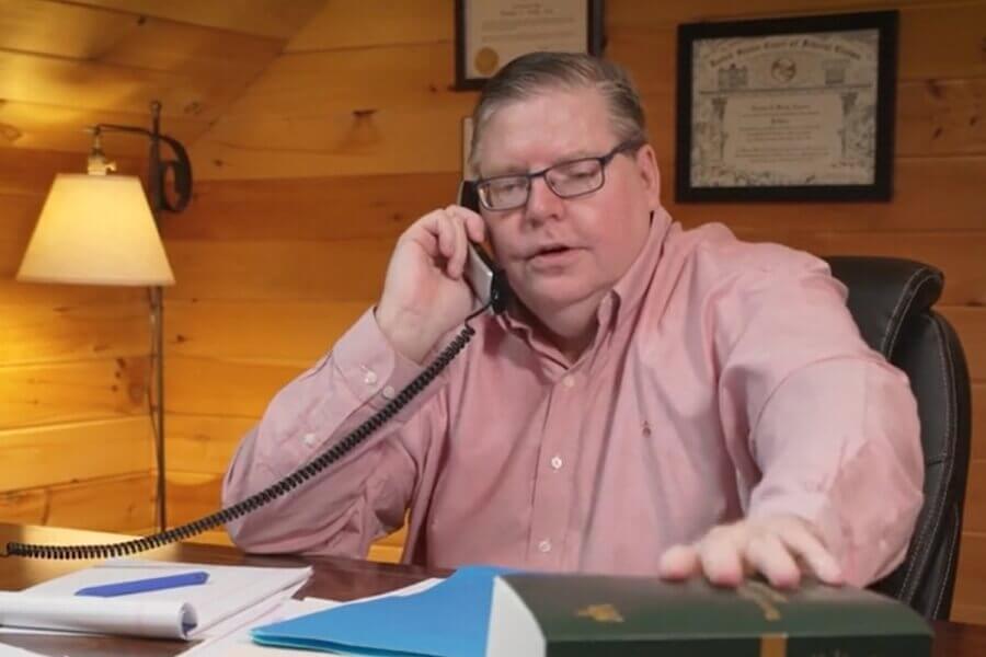 Personal injury attorney, Tom Bixby in Rutland, Vermont meeting with a client on the phone.